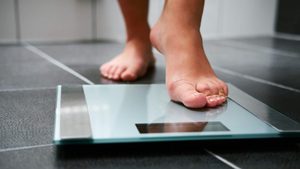 woman stepping on to a scale